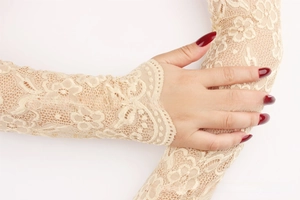 Detail of beige lace sun protection sleeve featuring elegant floral hollow-out patterns