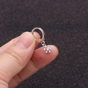 Close-up of silver star earring with micro-pave zircons held in hand over black foam