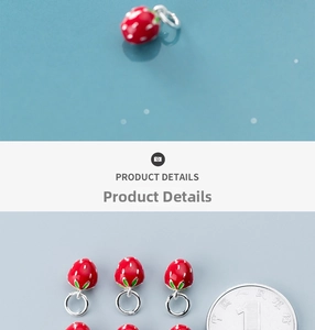 Detail of red enamel strawberry pendant with green leaves for DIY jewelry making