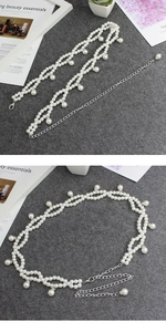 Detail of white pearl woven waist chain with silver metal extender and lobster clasp