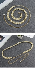 Detailed close-up of a gold metal waist chain with elegant white pearls on felt