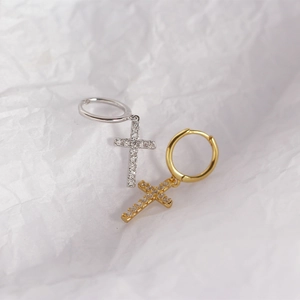 Detailed view of S925 sterling silver cross huggie earrings in gold and silver finishes