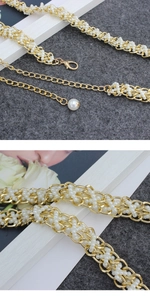 Detail of beaded pearl waist chain with golden metal links and lobster clasp fastener