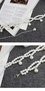 Detail of multi-layer white pearl necklace featuring large teardrop beads and silver lobster clasp