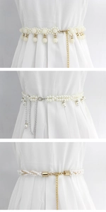 Detail of elegant pearl waist chains with gold and silver metal accents on a white dress