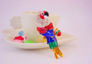 Detailed macro shot of a colorful enamel parrot brooch with sparkling crystal rhinestones