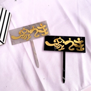 Detail of gray marble and black acrylic cake toppers with elegant gold Japanese script