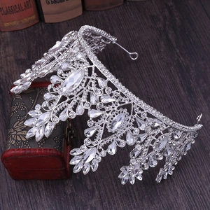 Close-up of sparkling crystals on a silver bridal tiara against a vintage wooden background