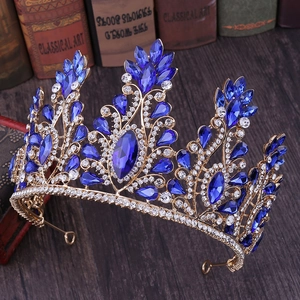 Regal gold tiara crown featuring blue rhinestones and elegant crystal swirl patterns
