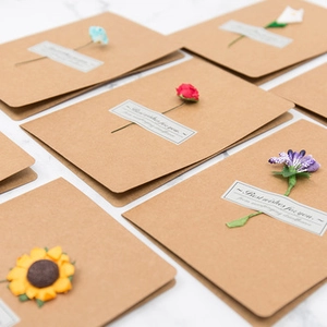 Close-up of assorted dried flower bouquets on minimalist kraft paper greeting cards