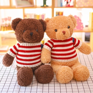 Ositos de peluche marrones con suéteres de rayas rojas en un mantel de cuadros