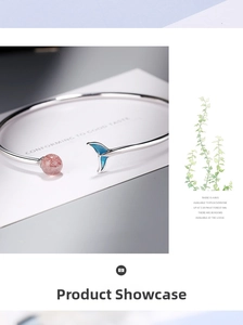 Detail view of silver whale tail bracelet featuring pink strawberry quartz and blue enamel