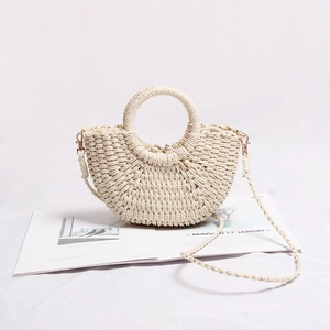 Detail of a mini beige straw bag with circular handle and fabric drawstring inner pouch