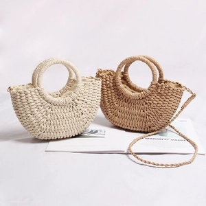 Detail of half-moon straw woven bags with circular handles and drawstring fabric lining