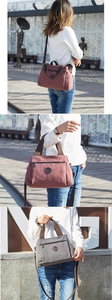 Outdoor urban shot of models carrying pink and grey canvas tote bags with leather logos