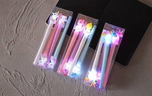 Dettaglio di penne gel luminose con unicorno e orso in scatole regalo trasparenti