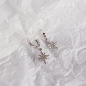Detailed close-up of a S925 sterling silver hoop earring with a sparkling star pendant