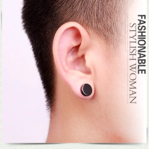 Close-up of minimalist black magnetic stud earrings on a model ear with matte finish
