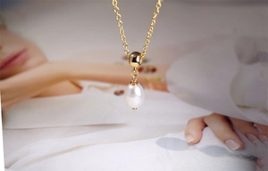 Macro detail of teardrop freshwater pearl pendant on a fine gold titanium necklace
