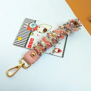 Detail of pink floral fabric strap with pearls and gold metal lobster clasp