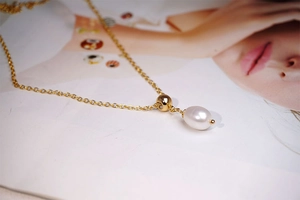 Close-up of elegant gold water drop freshwater pearl necklace on a fashion magazine