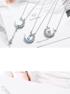 Detailed view of silver moon and star necklaces with blue zircon fringe and teardrop stone