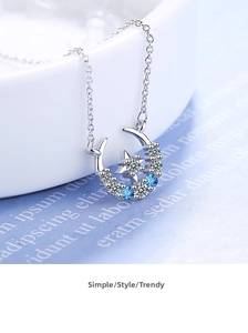 Close-up of crescent moon necklace with blue and white zircons on a silver chain