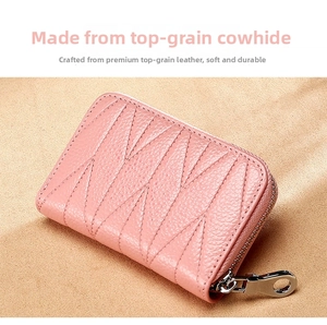 Dettaglio del porta carte in pelle rosa con trama litchi e cerniera metallica d'argento
