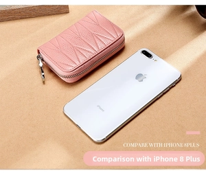Portacarte in pelle rosa con motivo trapuntato mostrato accanto a iPhone 8 Plus per dimensioni