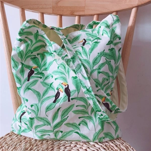 Detailed shot of cotton tote bag with tropical leaf and colorful toucan bird prints
