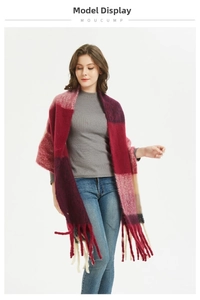 Detail view of a soft oversized plaid scarf with tassels in deep red and navy tones