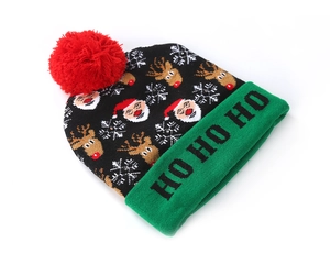 Macro detail of Christmas knit beanie with Ho Ho Ho text, plush pom pom and festive patterns