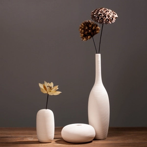 Detailed view of spiral texture on beige ceramic vases with dried lotus seeds decor
