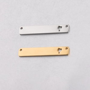 Detail of silver and gold stainless steel tags featuring hollow coconut tree designs