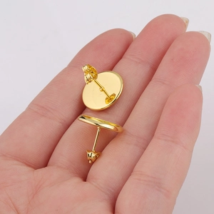 Pair of polished 12mm gold-plated stainless steel stud earring bases shown on palm