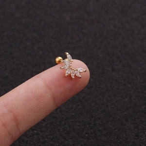 Detailed view of tiny gold stud earring with marquise white zircon on fingertip