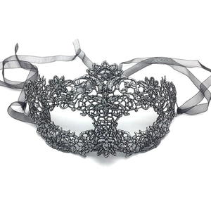 Detailed close-up of delicate black lace masquerade mask with intricate floral embroidery