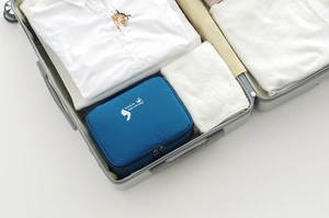 Detail of navy travel storage bag with zipper in a suitcase showing packing capacity
