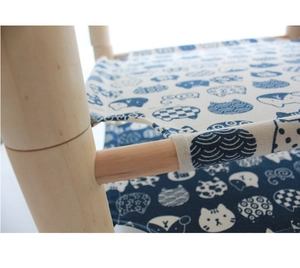 Detail of wooden pet hammock frame with blue and white cat print canvas fabric texture