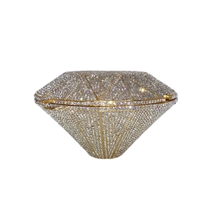 Macro shot of silver crystal rhinestones on the golden frame of a diamond-shaped clutch