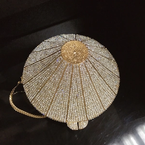 Detailed view of silver crystal diamond evening clutch with gold chain and spherical clasp