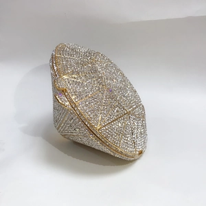 Macro detail of diamond-shaped evening clutch bag with sparkling crystals and gold metal frame