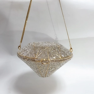 Detail of diamond-shaped evening clutch bag with full crystal rhinestones and gold chain
