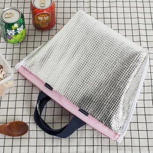 Insulated lunch bag with silver quilted fabric, pink zipper and dark blue handles