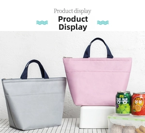 Detail view of light grey and pink insulated oxford fabric lunch bags with front pockets