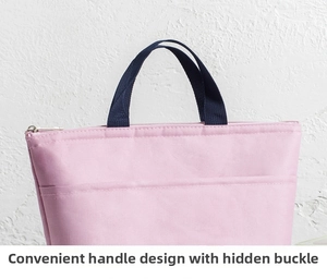 Detail of pink lunch bag with dark blue woven handles and secure metal zipper