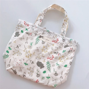 Detail of floral and animal pattern print on beige canvas tote bag with zipper