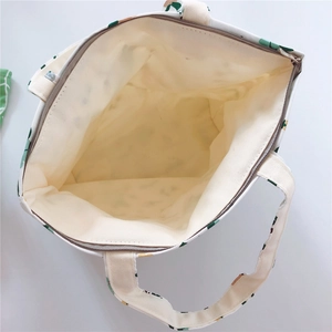 Top view of spacious canvas tote interior with zipper closure and leaf print pattern