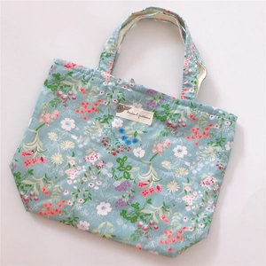 Close-up of floral pattern cotton tote bag with handle and animal patterns label