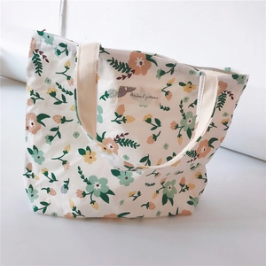 Close-up of small floral canvas tote bag with zipper closure and woven handles
